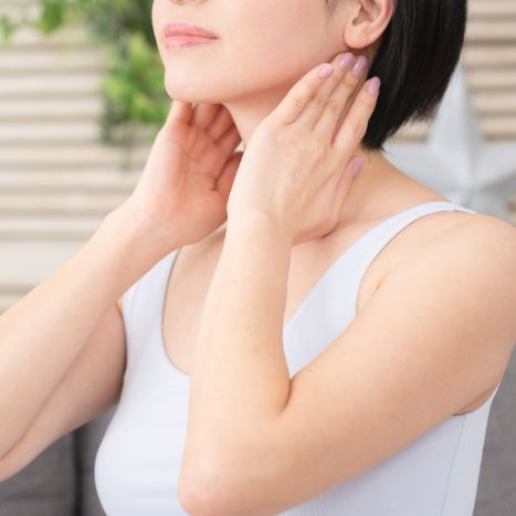 首元に天然ハーブ軟膏を塗り込む女性